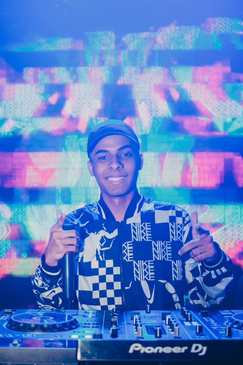 Felipe Único smiling behind the decks during a show